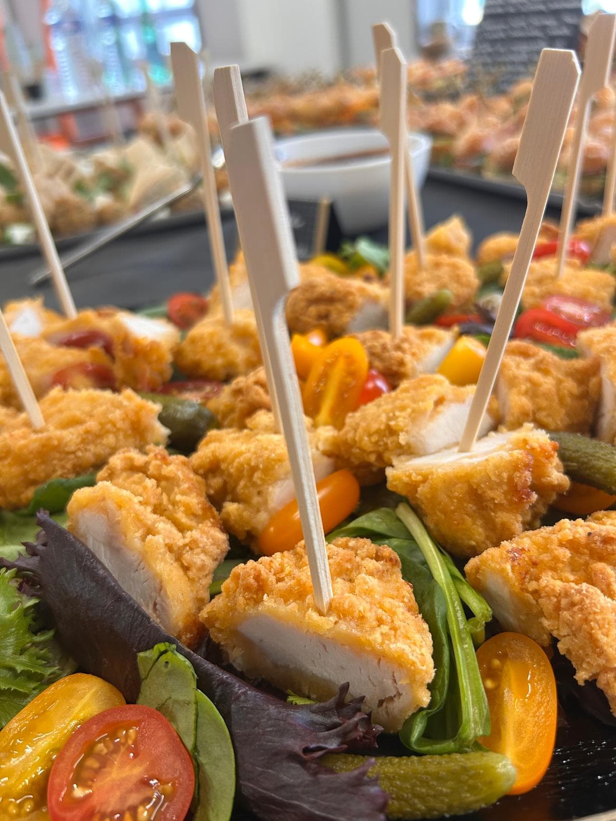 Brochettes de poulet pané sur pique, dressées sur mesclun